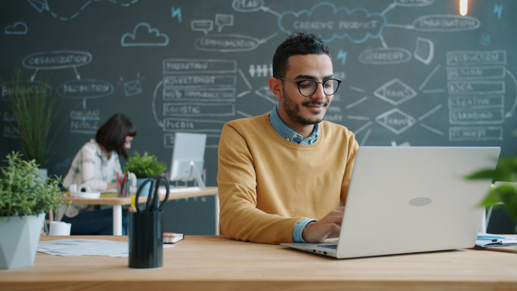 Smiling traffic specialist working on a laptop in a modern office