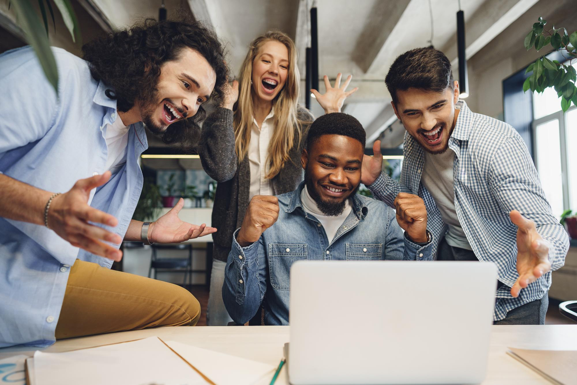 Station team celebrating results around a laptop