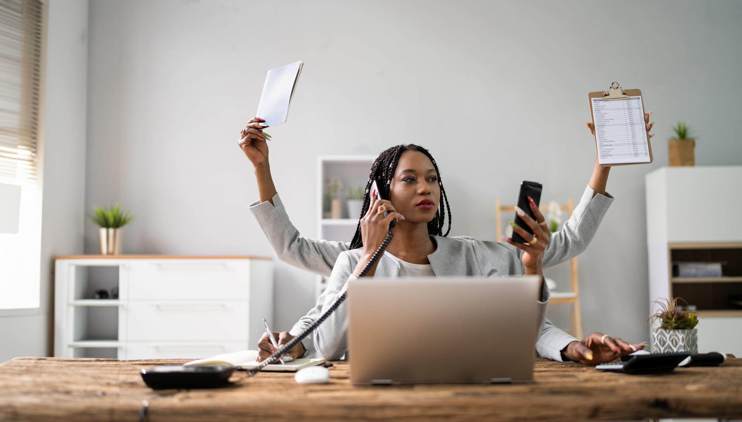 Station team member juggling phone calls and paperwork at a desk